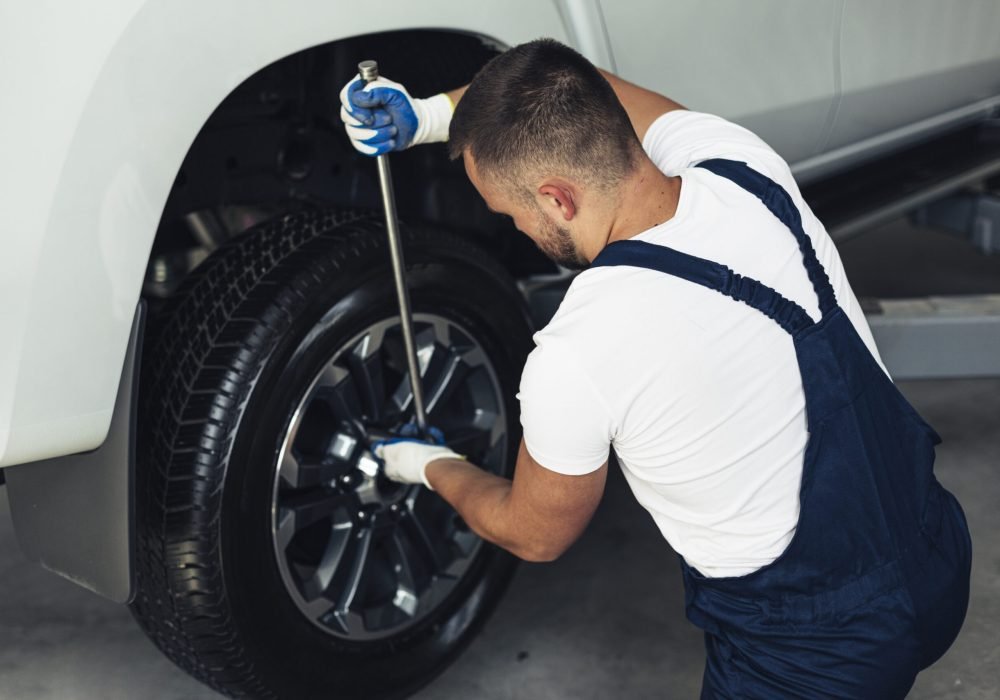high-angle-male-mechanic-changing-car-wheels