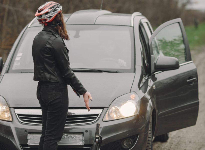 The woman crashed into the car. Girl in a helmet. People quarrel over the accident.